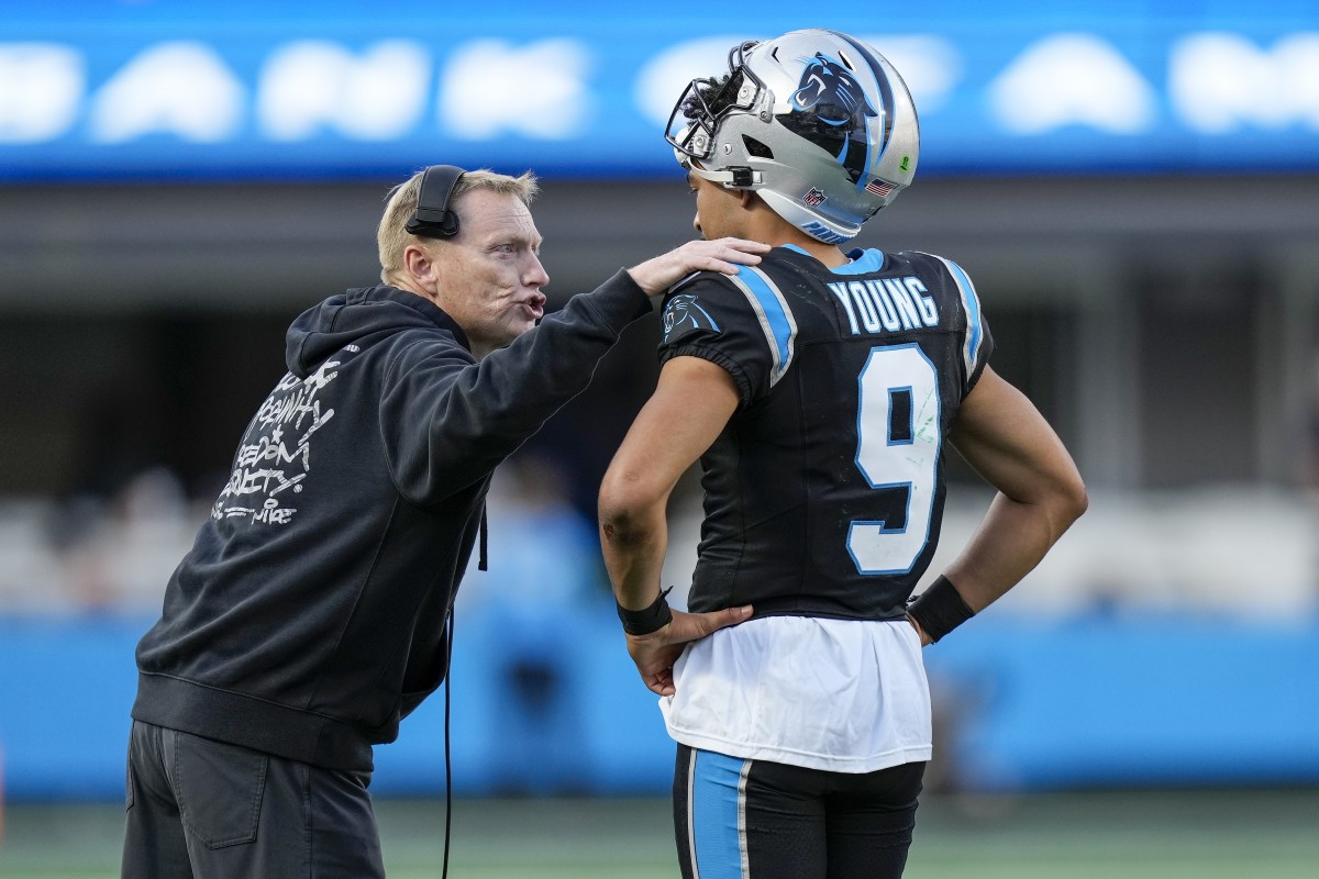 Chris Tabor puts a hand on Bryce young’s shoulder as he leans over talking to him